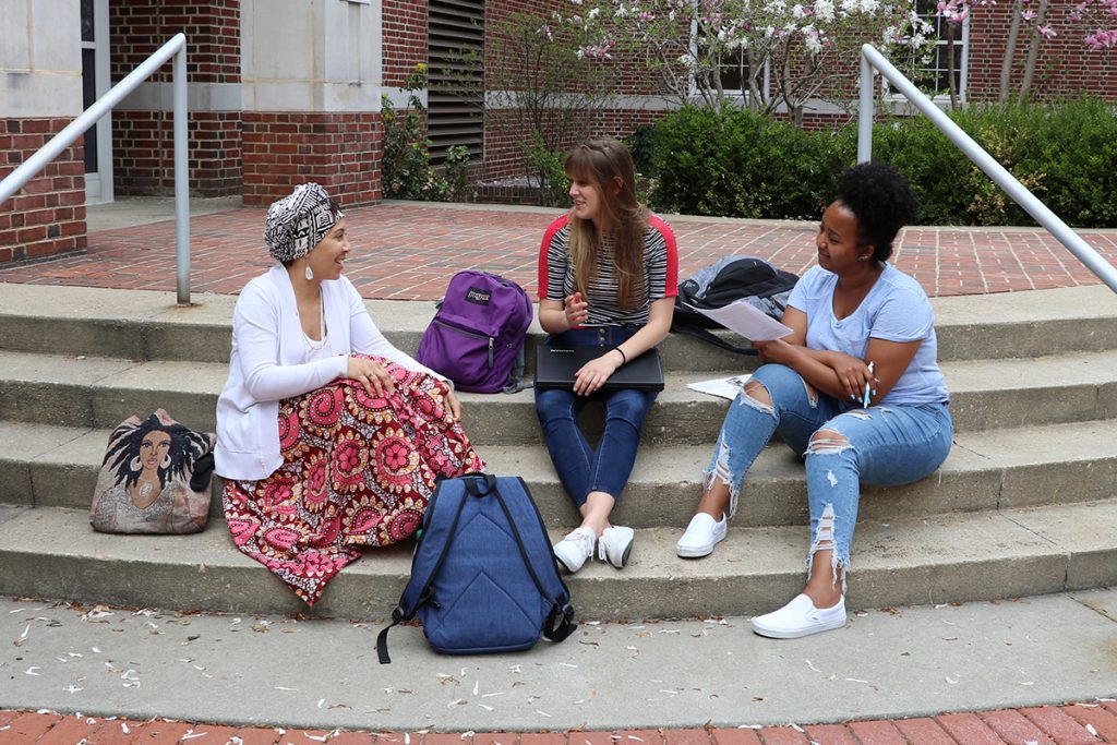 Three students sitting outside